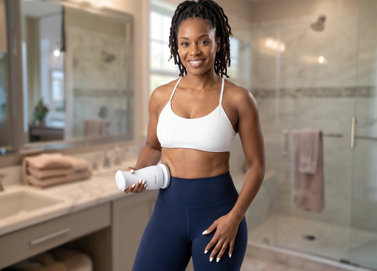 Woman in a bathroom holding the Vibro Sculpt Pro